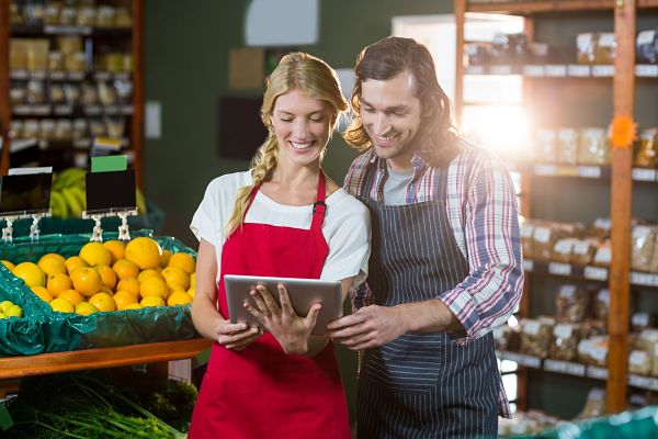 grocery store staff using digital checklists on a tablet