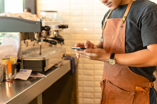 staff looking into mobile for health and safety sops of restaurants