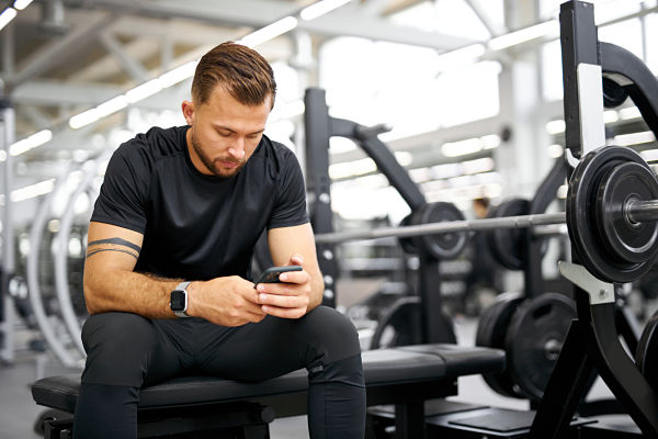 gym manager on his smartphone