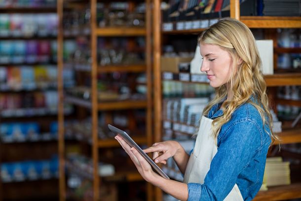 female staff using tablet device in supermarket