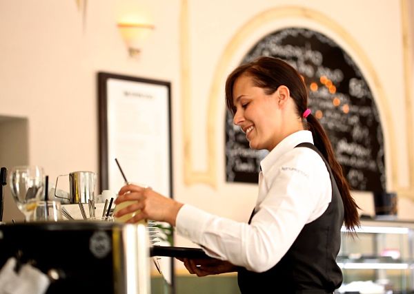 Happy waitress making a drink